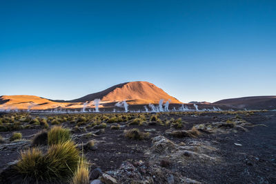 Scenic view of desert against clear blue sky