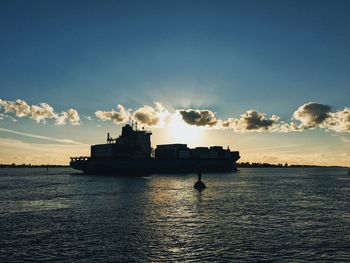 Silhouette boat in sea against sky during sunset