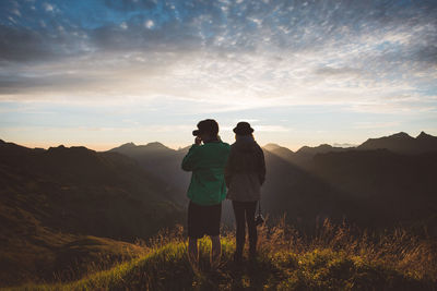 Rear view of women standing against mountains