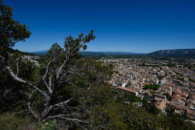 Buildings in town against clear blue sky