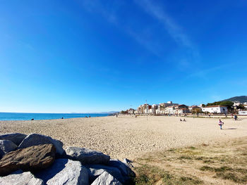 Scenic view of beach against blue sky