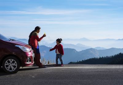 Mother and daughter on a road trip. car travel vacation concept photo against himalayan mountain.