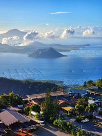 High angle view of townscape by sea against sky during sunset