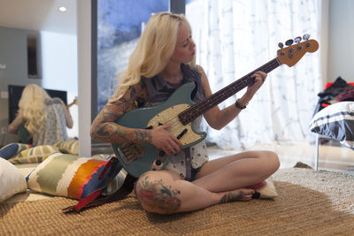 Beautiful young woman playing an electric guitar