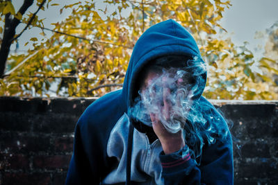 Portrait of a teenage boy holding camera