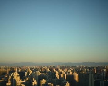 Aerial view of cityscape against clear blue sky