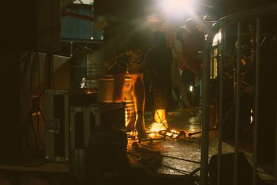 People standing in illuminated fire at night