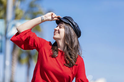 Smiling teenage girl wearing red top in city during sunny day