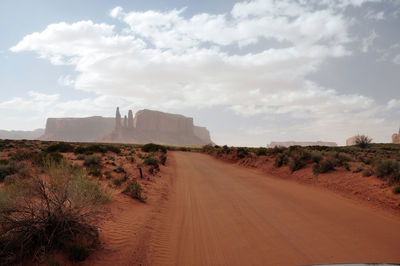 Road amidst desert against sky