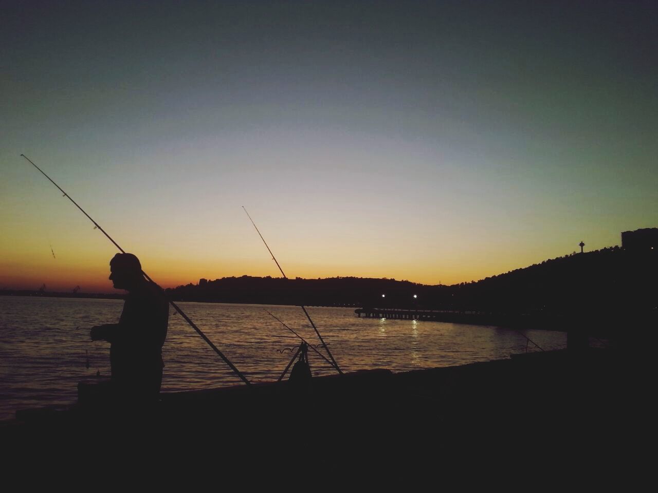 sunset, silhouette, water, orange color, sea, scenics, tranquility, beauty in nature, tranquil scene, sky, copy space, nature, clear sky, dusk, idyllic, sun, lake, outdoors, fishing, river