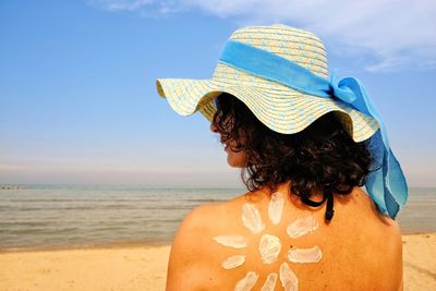 Rear view of woman wearing hat on beach