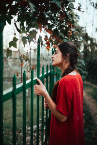 Girl leaning on fence on rural property