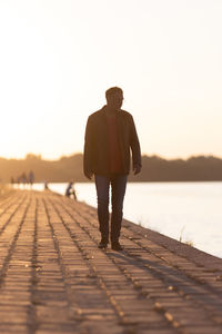 Single man walking on river edge