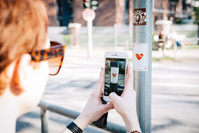 Midsection of woman photographing in city