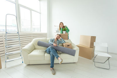 Rear view of woman sitting on sofa at home