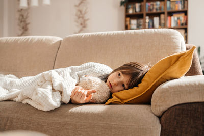Young woman sitting on sofa at home