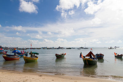 Boats moored on sea against sky