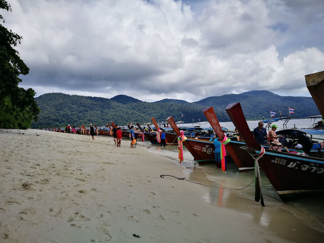 PEOPLE ON BEACH AGAINST SKY