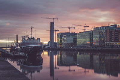 Reflection of cityscape in water at sunset