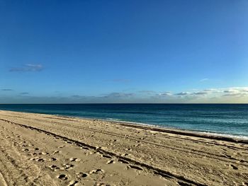 Scenic view of beach against blue sky