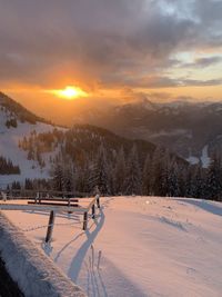 Scenic view of snow covered landscape against sky during sunset