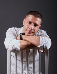 Portrait of young man looking away against black background