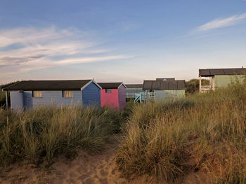 Houses by beach against sky