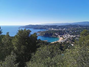 High angle view of townscape by sea against clear sky