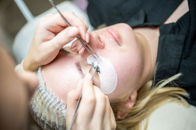 High angle view of customer applying eye patch at salon