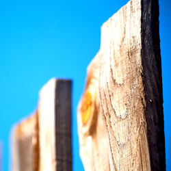 Low angle view of wood against clear blue sky