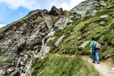 Rear view of backpacker walking on mountain