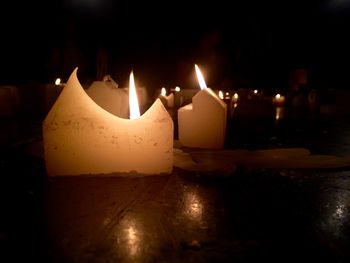 Lit candle in dark room