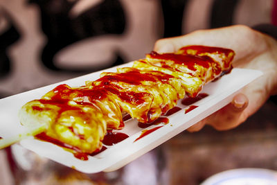 Close-up of person holding food served on table