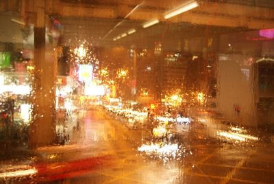 Illuminated city street during rainy season at night