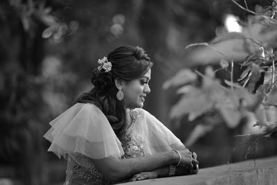 Side view of young woman sitting outdoors