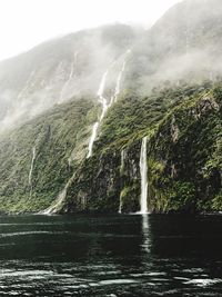 Water splashing on mountain against sky