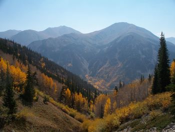 Scenic view of valley and mountains against sky in foggy weather 