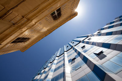 Low angle view of buildings against clear blue sky