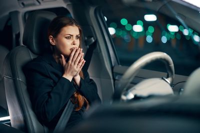 Fright face of young woman sitting in car