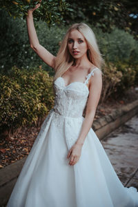 Happy woman with arms raised standing outdoors