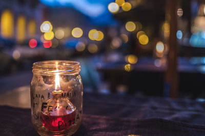 Close-up of illuminated oil lamp on table