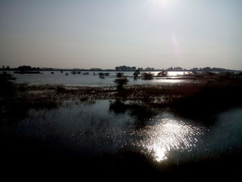 Sun shining through clouds over river