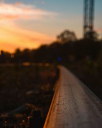 Close-up of railroad track against sky during sunset