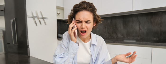 Young woman using mobile phone at home