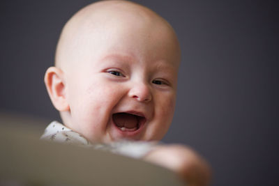 Close-up portrait of cute baby boy laughing