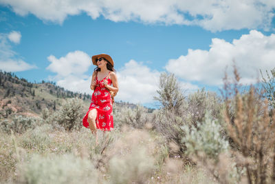 Woman standing on field against sky