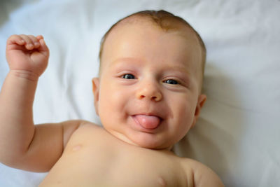 Portrait of cute baby lying on bed