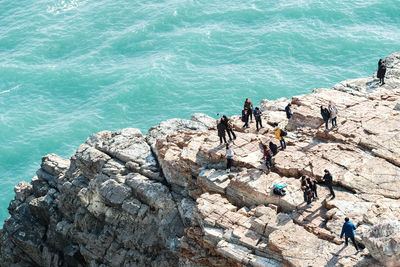 High angle view of people on rock by sea