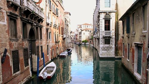 Boats moored at grand canal amidst buildings