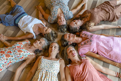 Group of friends with eyes closed lying together on floor